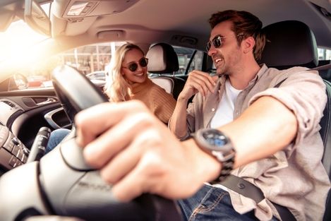 couple driving car at golden hour