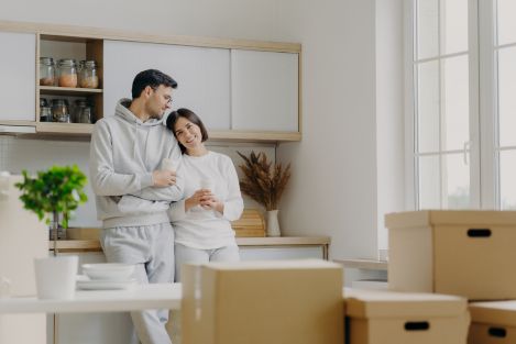 couple wearing grey clothes moving into an apartment