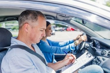 junge Frau nach einer Fahrprüfung in einem Auto