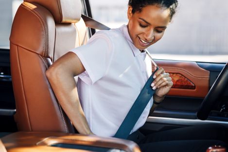 woman putting on seatbelt